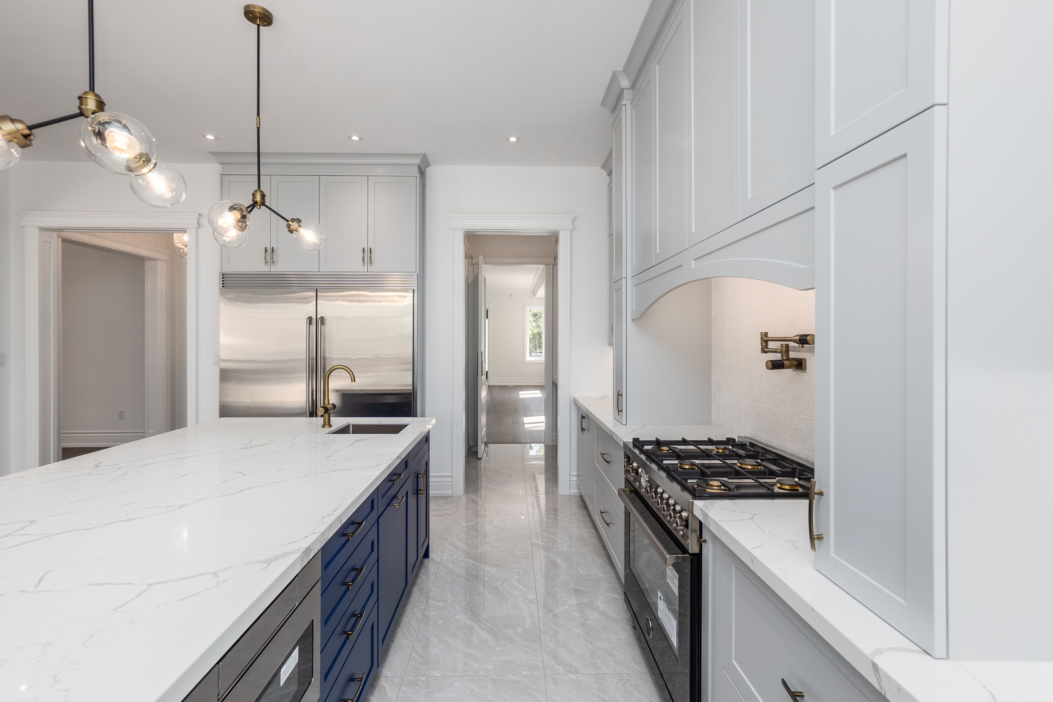 Galley kitchen with blue island and brass